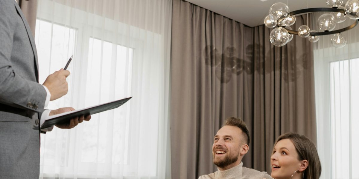 A couple discusses potential property choices in a stylish apartment, envisioning their new lifestyle.