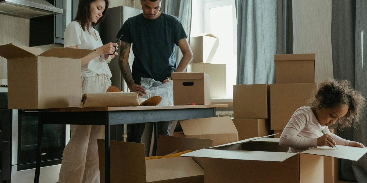A family unpacking boxes in a new, bright living room, depicting the smooth transition facilitated by an expat-focused agency.
