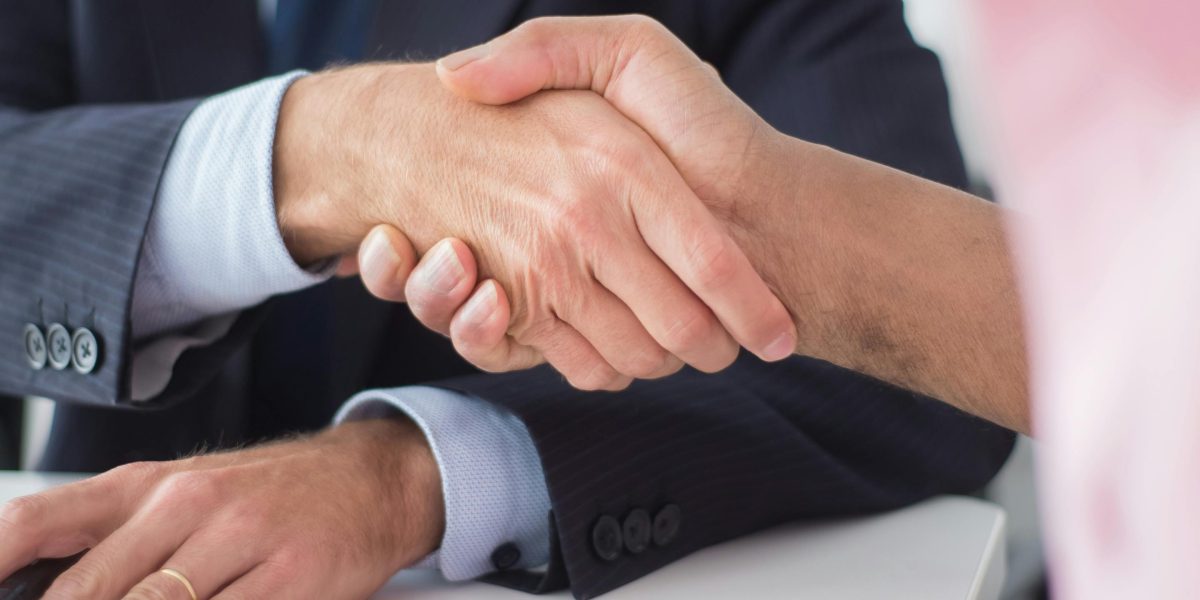A professional handshake symbolizing trust and a successful partnership in a real estate transaction.