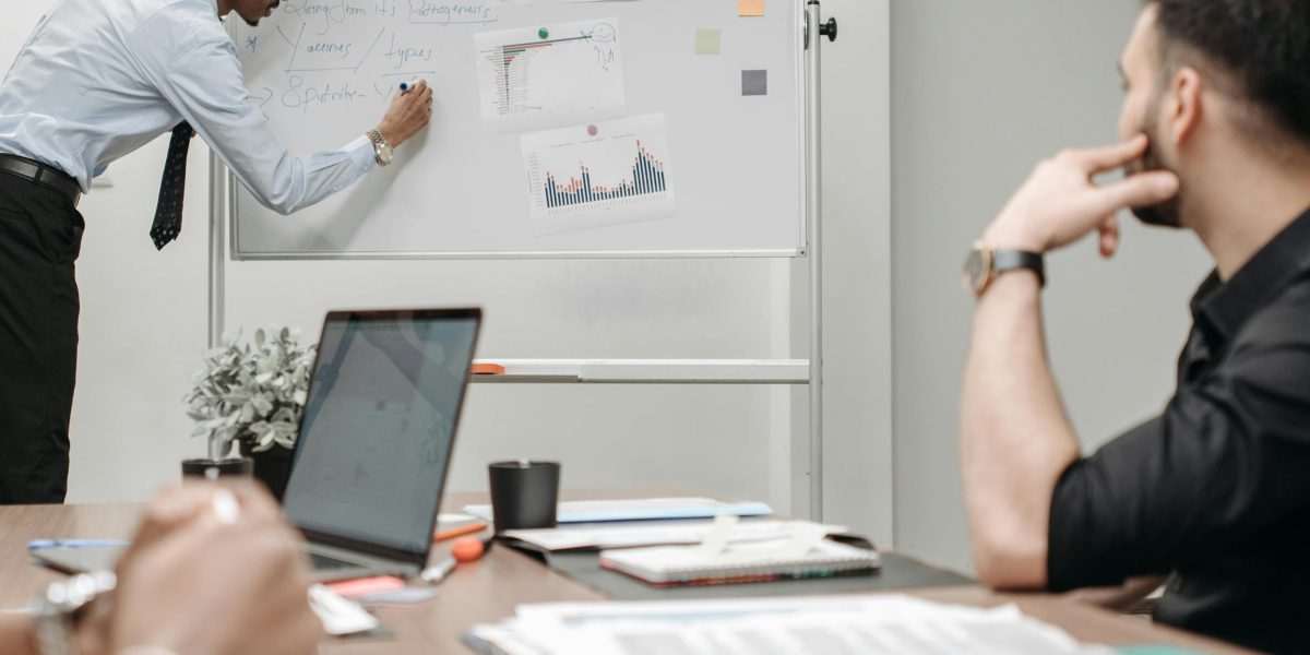 A team collaborating around a whiteboard, representing the integrated services of a top real estate brokerage.