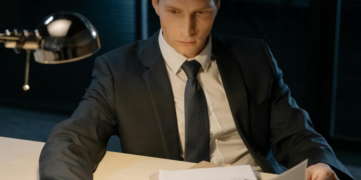 Someone carefully reviewing documents, emphasizing the need for due diligence.
