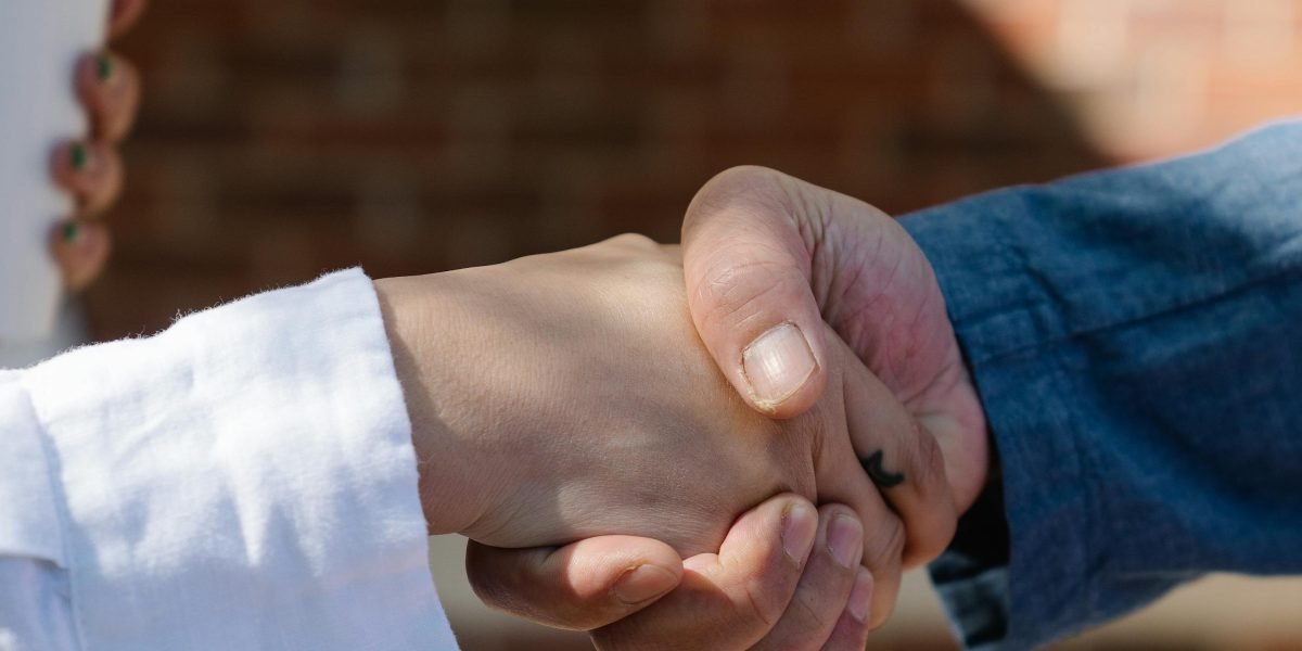 Two professionals shaking hands, symbolizing a successful and smooth property transaction.