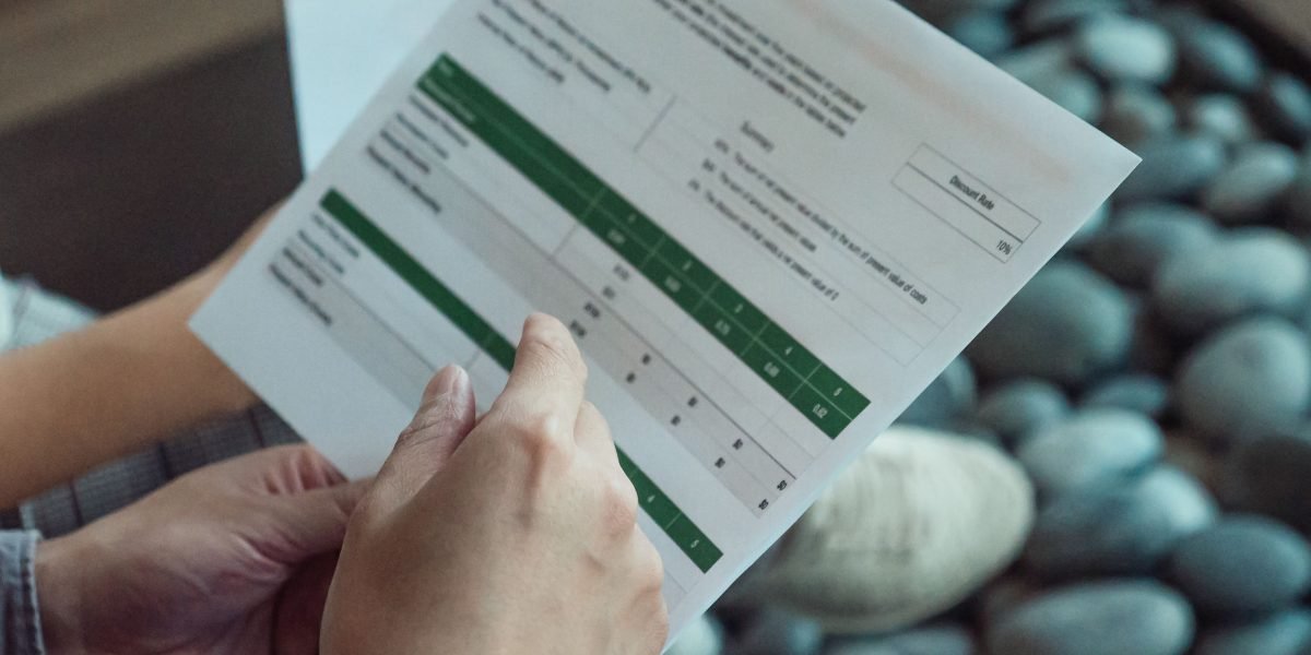 A person reviewing financial documents, symbolizing the strategic planning involved in financing luxury real estate investments.