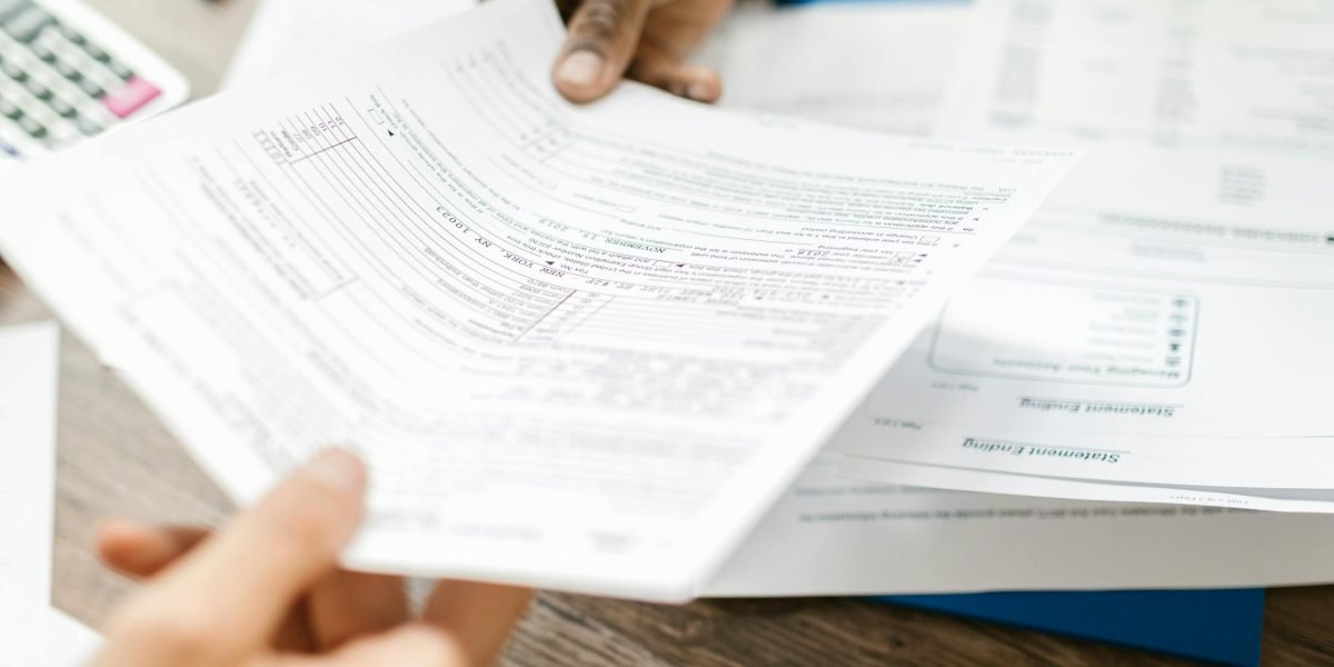 Individuals carefully reviewing financial documents, representing the importance of understanding real estate costs and budgeting.